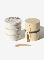 Stack of white containers with a beige lid and wooden tool on a white background, featuring the brand 'Ecani'.