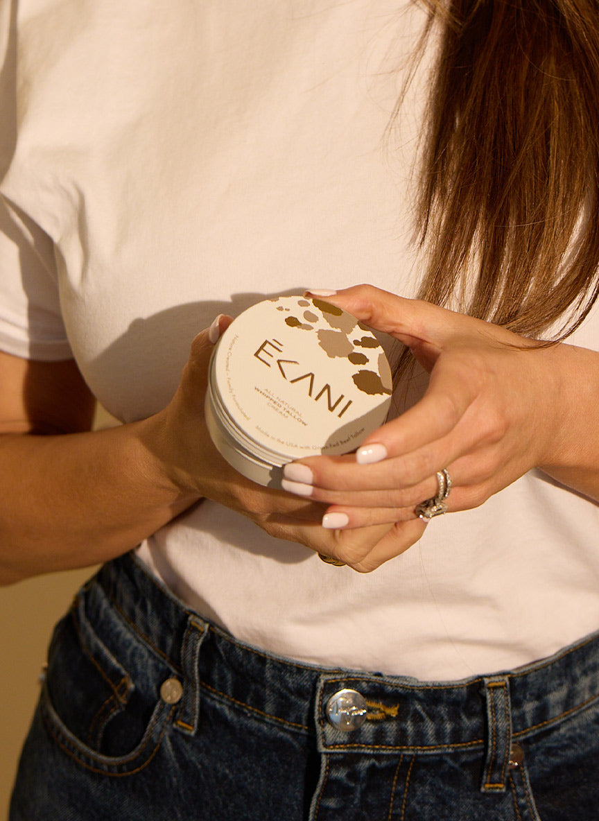 Person holding a container with 'Ecani' branding Ecani all natural whipped tallow cream container with cow print design